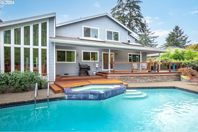 back of property with a pool with hot tub