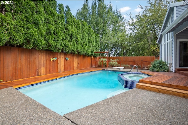 view of swimming pool featuring an in ground hot tub, a diving board, and a deck