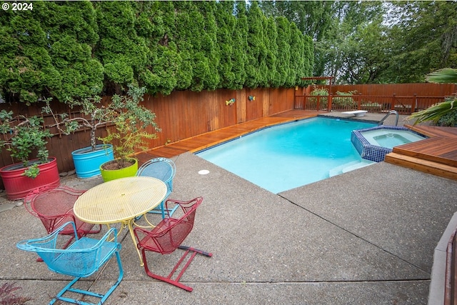 view of swimming pool featuring an in ground hot tub, a deck, and a diving board