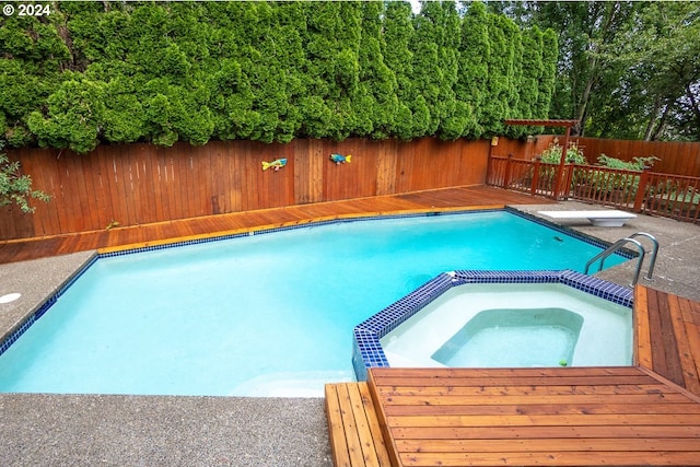 view of pool featuring an in ground hot tub, a diving board, and a deck