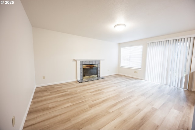 unfurnished living room with a fireplace and light hardwood / wood-style flooring
