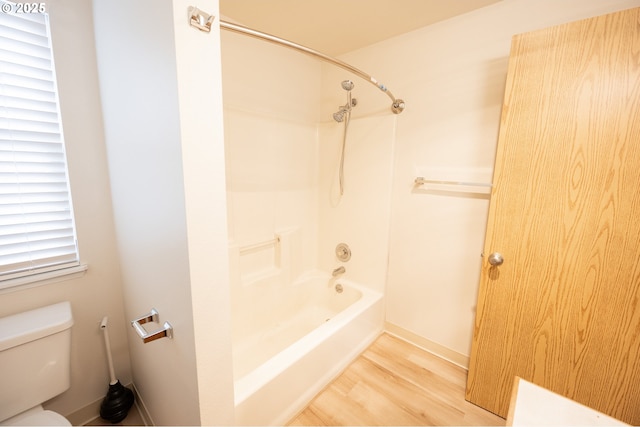 bathroom featuring toilet, hardwood / wood-style floors, and shower / tub combination