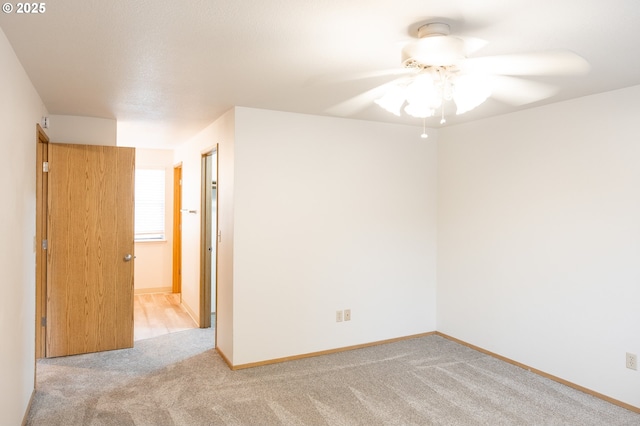 spare room with ceiling fan and light carpet