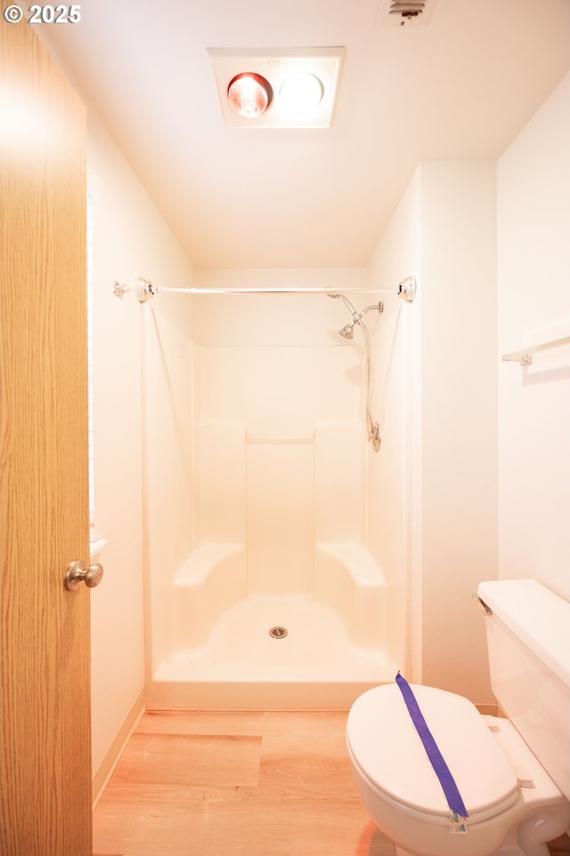 bathroom featuring wood-type flooring, toilet, and walk in shower