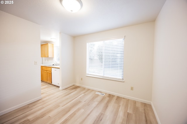 unfurnished room with sink and light wood-type flooring