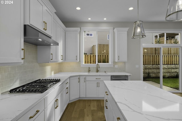 kitchen with stainless steel appliances, decorative light fixtures, a wealth of natural light, and sink