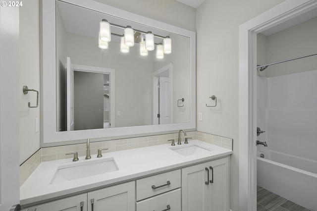 bathroom featuring washtub / shower combination, vanity, and tasteful backsplash