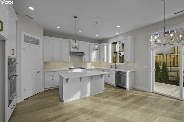 kitchen featuring a center island, light wood-type flooring, white cabinetry, and appliances with stainless steel finishes