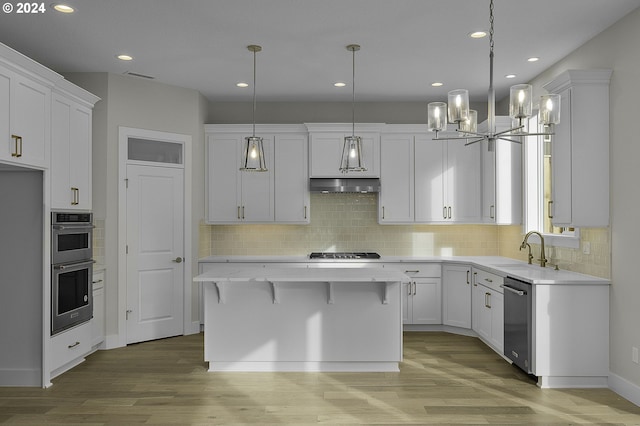 kitchen with white cabinetry, sink, hardwood / wood-style floors, a kitchen island, and appliances with stainless steel finishes