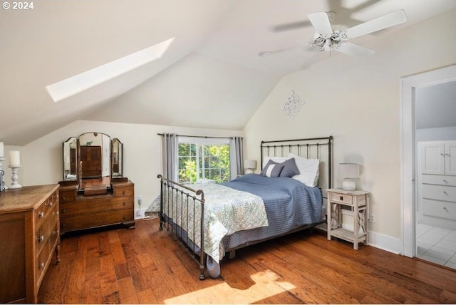 bedroom featuring ceiling fan, dark hardwood / wood-style floors, and lofted ceiling with skylight