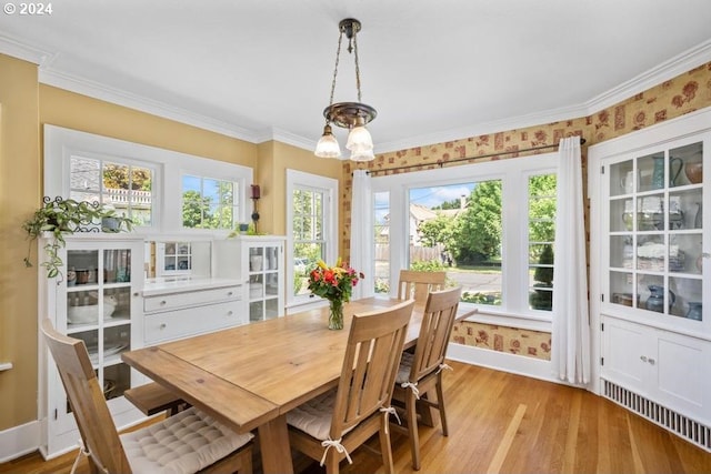 dining room with ornamental molding, light hardwood / wood-style floors, and a chandelier