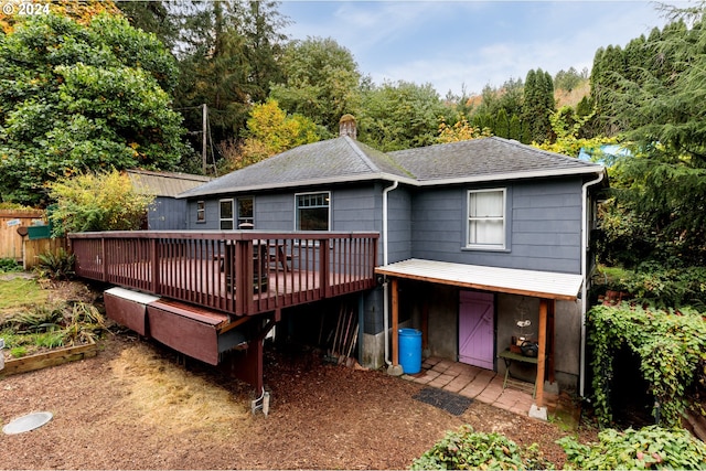 rear view of house featuring a wooden deck