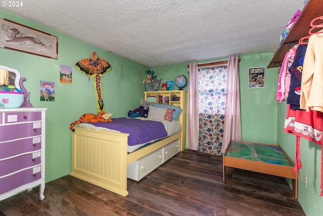 bedroom with a textured ceiling and dark hardwood / wood-style flooring