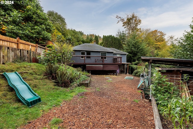 exterior space featuring a playground and a wooden deck