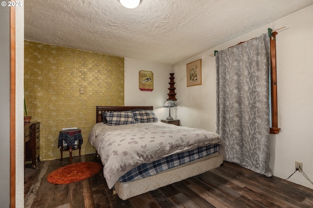 bedroom featuring a textured ceiling and dark hardwood / wood-style flooring