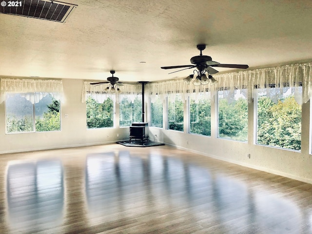 workout room with a wood stove, hardwood / wood-style flooring, and a healthy amount of sunlight