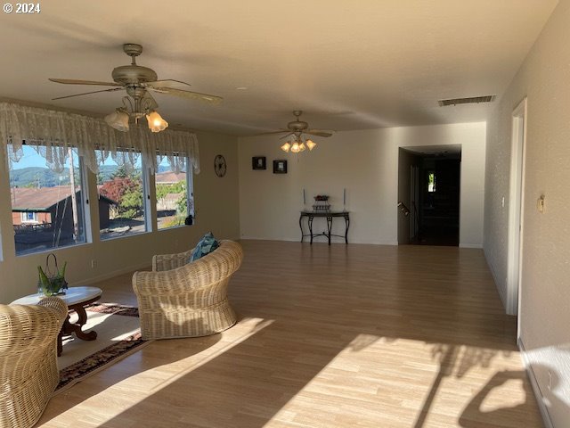 living room featuring ceiling fan and hardwood / wood-style flooring