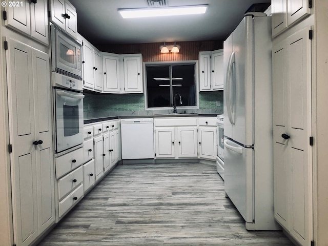 kitchen featuring backsplash, appliances with stainless steel finishes, white cabinetry, and sink