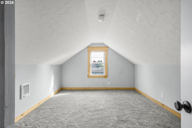 bonus room featuring lofted ceiling, a textured ceiling, and carpet flooring