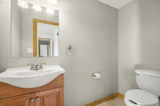 bathroom featuring vanity, hardwood / wood-style floors, and toilet