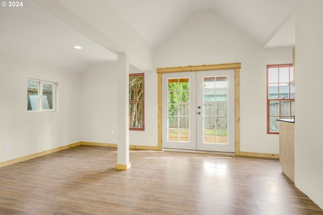 interior space with french doors, light hardwood / wood-style floors, and high vaulted ceiling