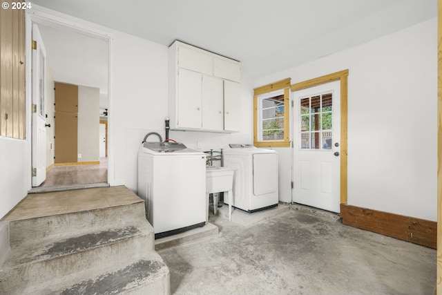 washroom with washer and clothes dryer and cabinets