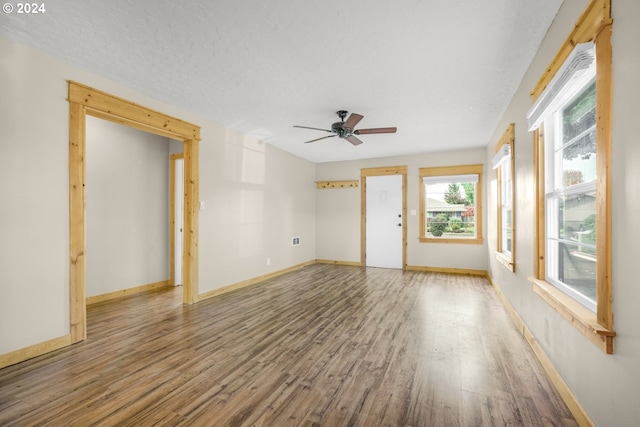 empty room featuring a textured ceiling, wood-type flooring, and ceiling fan