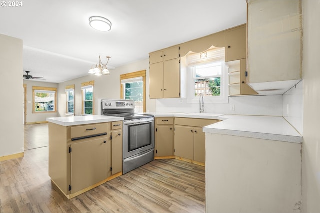 kitchen with stainless steel electric stove, kitchen peninsula, light wood-type flooring, ceiling fan with notable chandelier, and sink