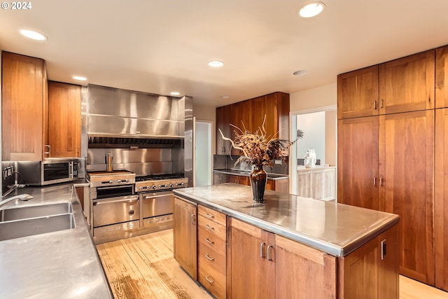 kitchen featuring stainless steel counters, sink, a center island, exhaust hood, and light wood-type flooring