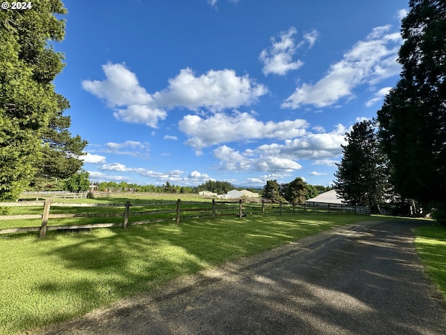 surrounding community featuring a lawn and a rural view