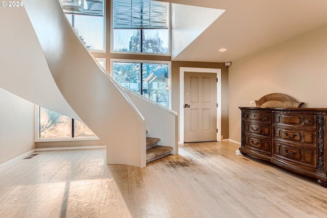 foyer entrance with a wealth of natural light and light hardwood / wood-style floors