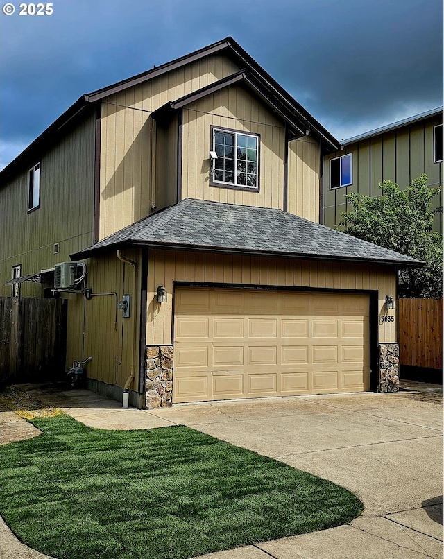 view of front of property featuring stone siding, an attached garage, fence, concrete driveway, and roof with shingles