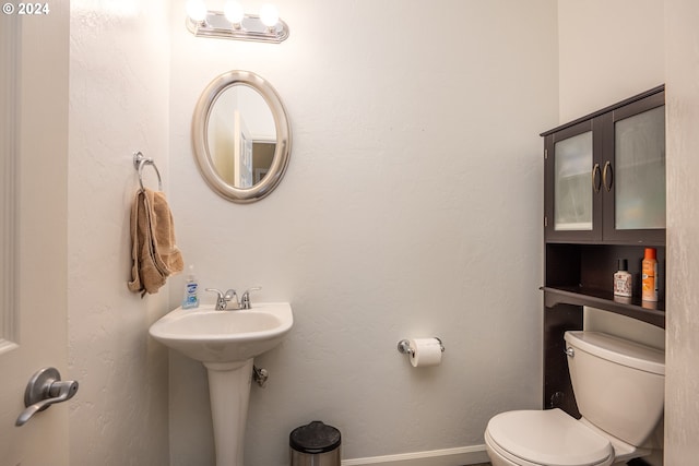 bathroom featuring toilet and baseboards