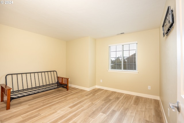 spare room featuring baseboards, visible vents, and wood finished floors