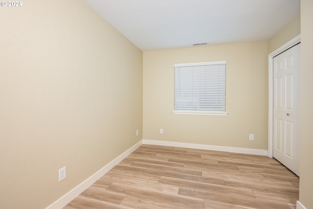 unfurnished bedroom featuring baseboards, a closet, visible vents, and light wood-type flooring