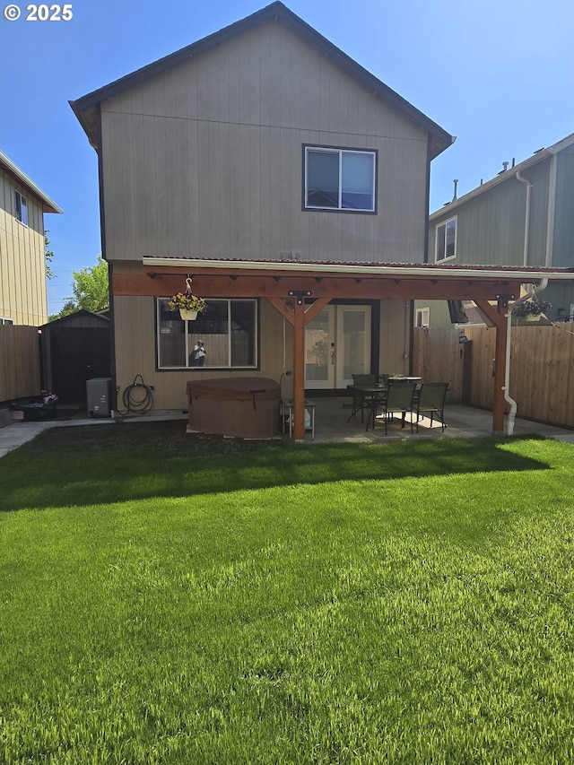 back of house featuring a hot tub, a patio area, fence, a lawn, and central AC unit