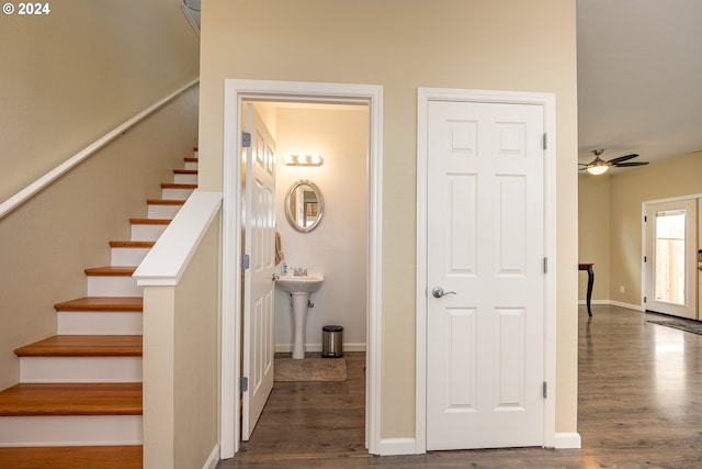 stairway featuring baseboards, wood finished floors, and a ceiling fan