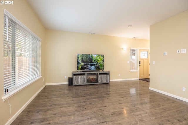 unfurnished living room with baseboards and wood finished floors
