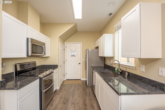 kitchen with visible vents, a sink, white cabinetry, wood finished floors, and stainless steel appliances