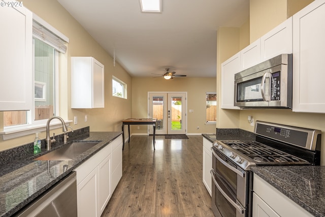 kitchen with ceiling fan, a sink, wood finished floors, stainless steel appliances, and white cabinets