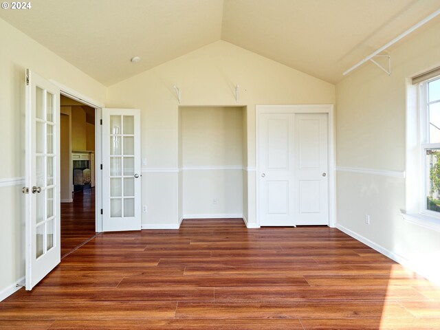 unfurnished bedroom with a closet, vaulted ceiling, french doors, and hardwood / wood-style flooring