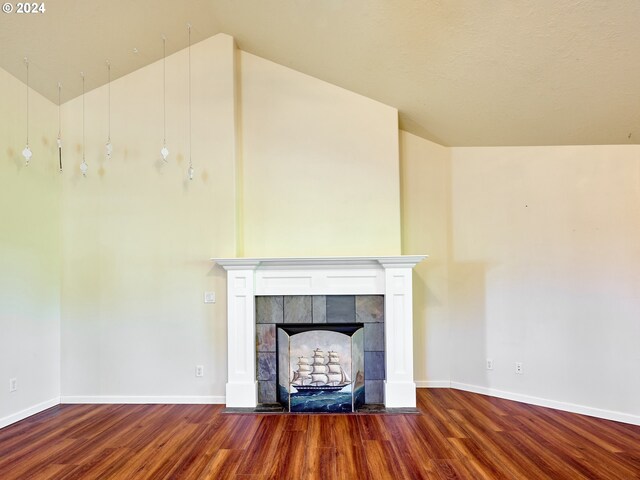 unfurnished living room featuring wood-type flooring, a fireplace, and vaulted ceiling