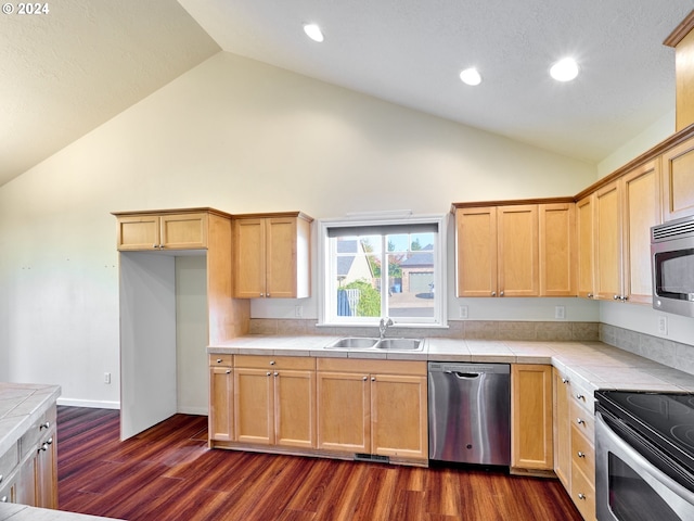 kitchen featuring tile countertops, appliances with stainless steel finishes, dark wood-type flooring, and a sink