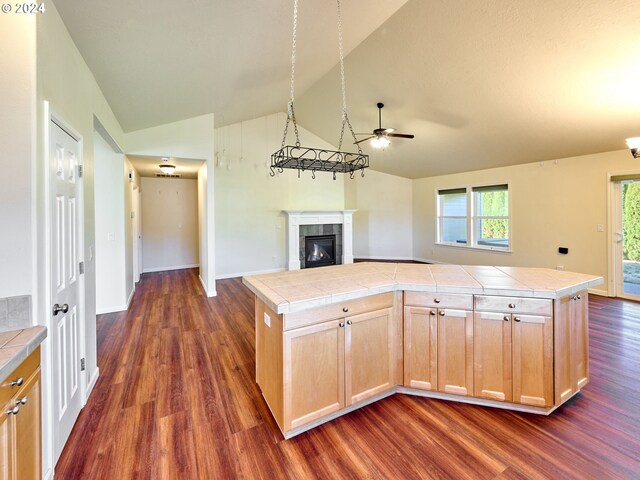 kitchen with tile countertops, vaulted ceiling, dark hardwood / wood-style flooring, and a center island