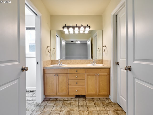 full bathroom with double vanity, stone finish flooring, and a sink