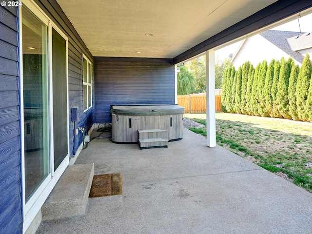 view of patio / terrace with fence and a hot tub