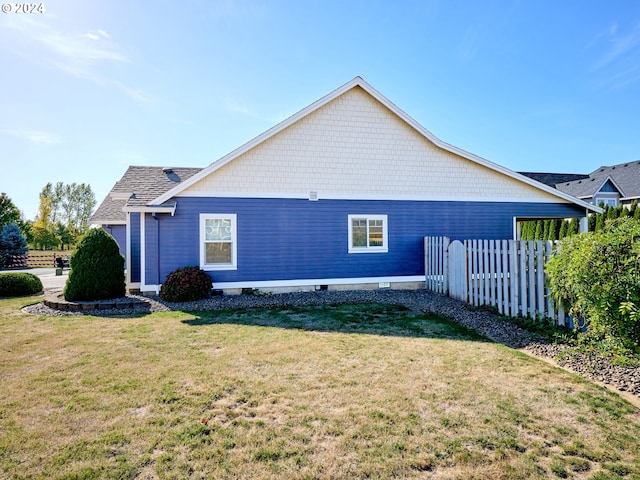 view of property exterior featuring fence and a yard