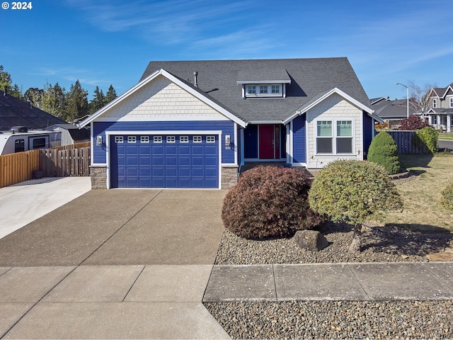 craftsman house featuring an attached garage, stone siding, driveway, and fence