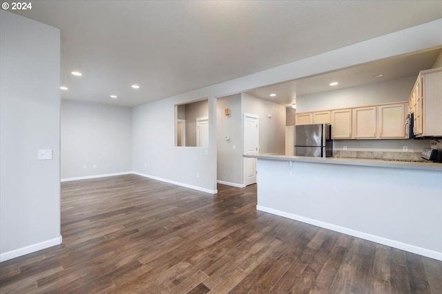 kitchen featuring a breakfast bar, stainless steel appliances, and dark wood-type flooring