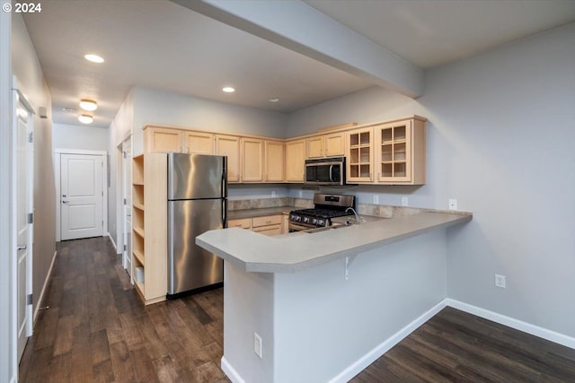 kitchen with a kitchen bar, kitchen peninsula, dark hardwood / wood-style floors, and appliances with stainless steel finishes